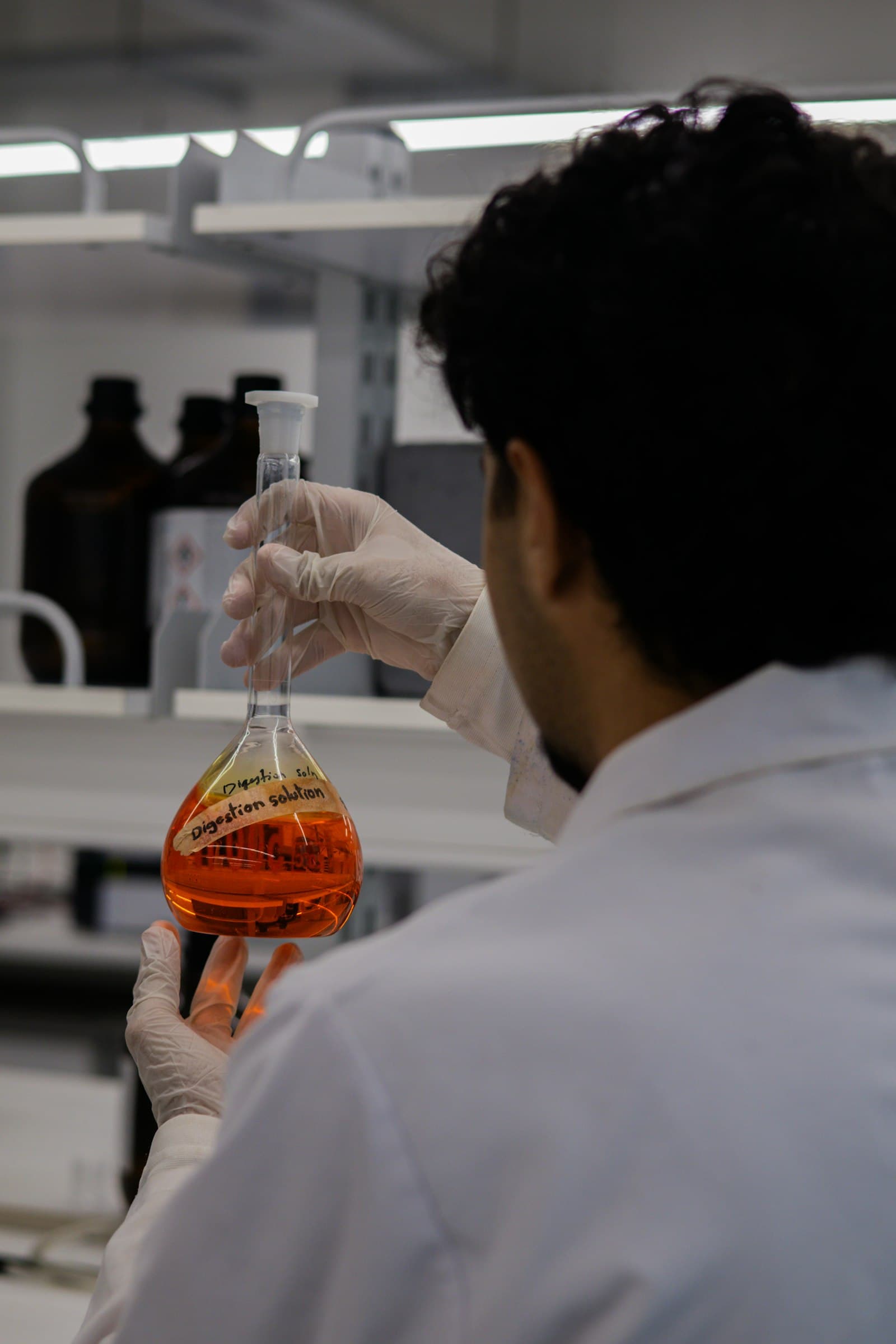 Scientist examining a volumetric flask in a research laboratory